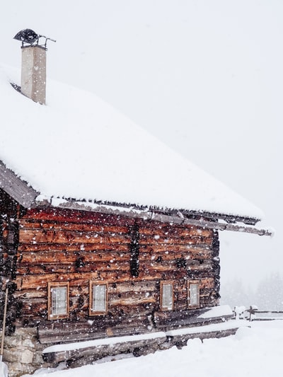 棕色的木头房子装满雪在雪
